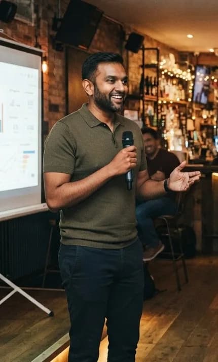 A speaker sharing a story with a packed room at a pub meetup